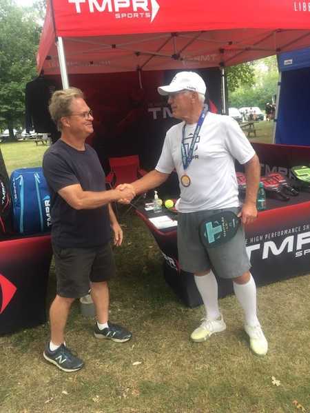 Coach Jim shaking hands with the owner of TMPR Sports